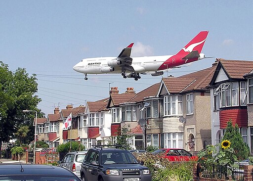 A Qantas Boeing 747-400 passes close to houses shortly before landing at London Heathrow Airport.