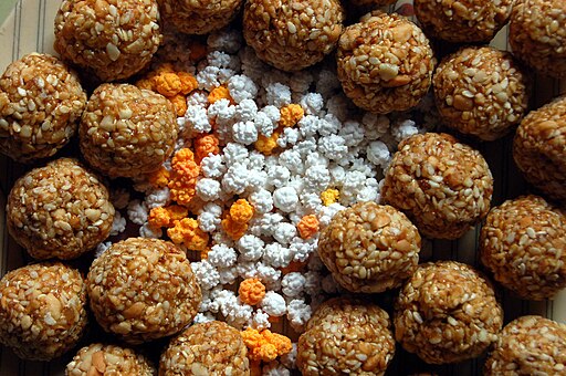 Multicolored sugar halwa surrounded by til-gul (sesame and jaggery) ladoos. These exchanged and eaten on Makar Sankranti in Maharashtra.